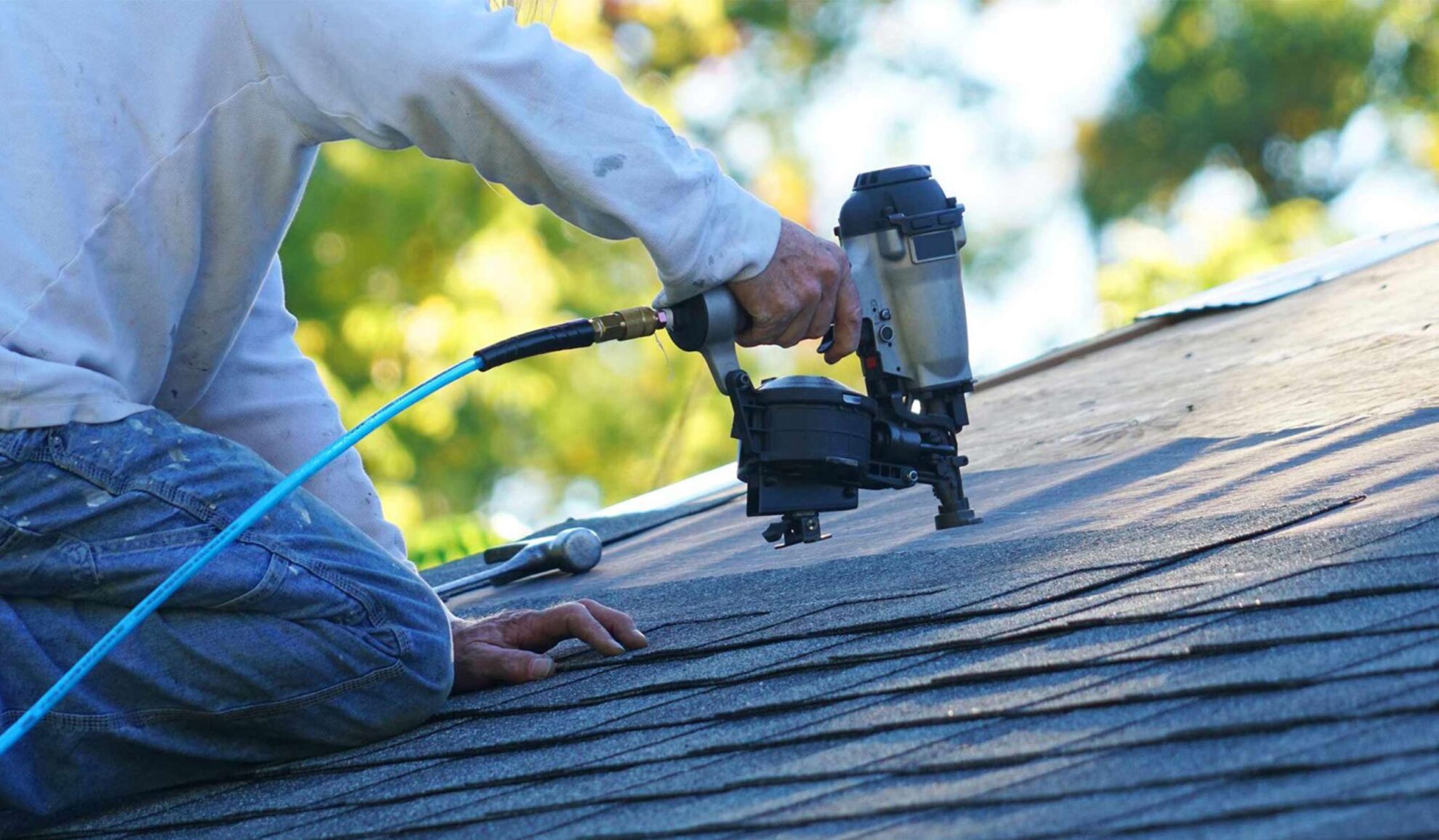 contractor with nailgun repairing asphalt shingles roof beaverton or